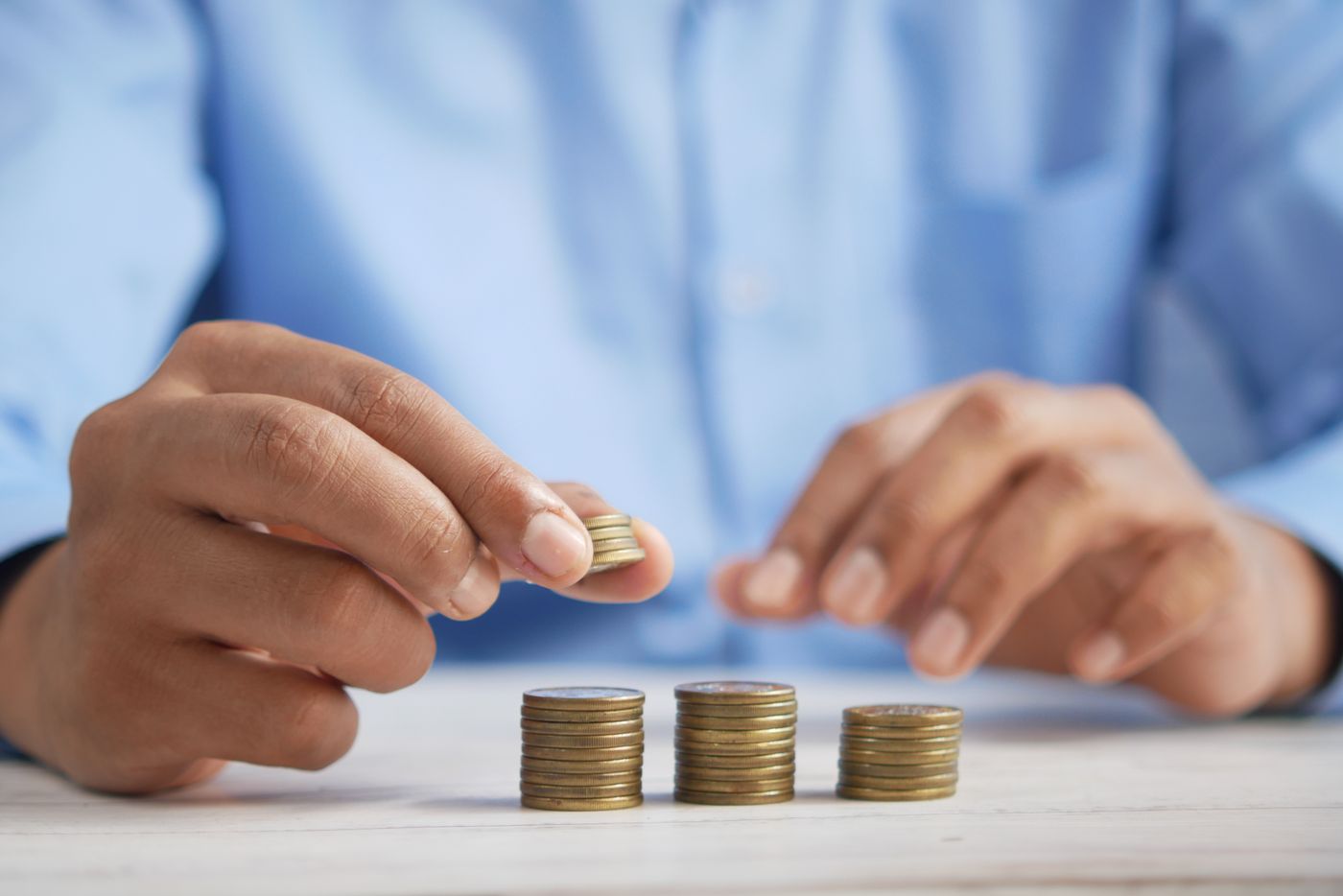 Hands stacking gold coins during valuation